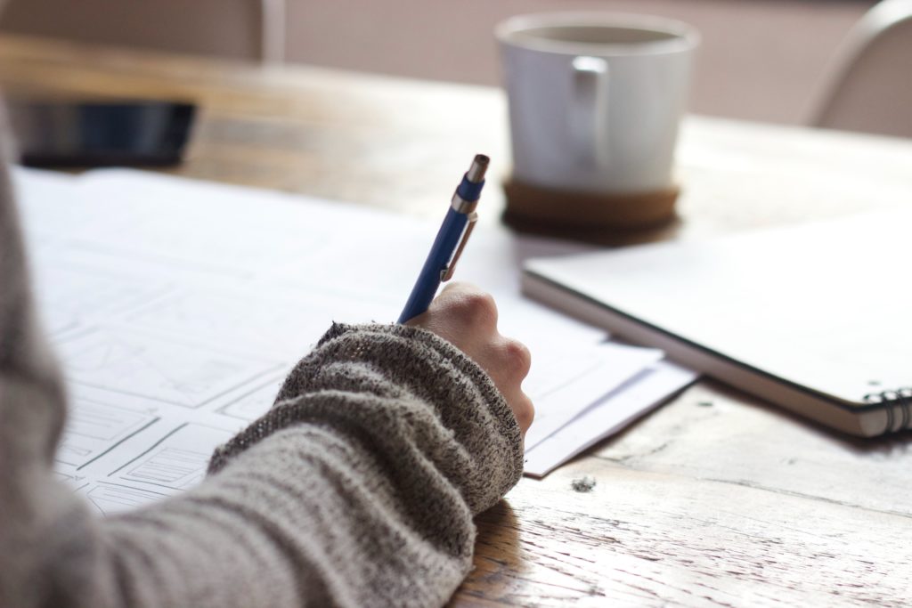 photo of person sketching notes with a pencil